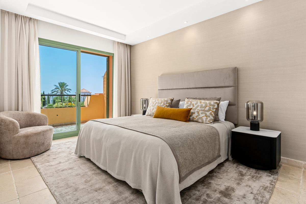 Bedroom with armchair and balcony view