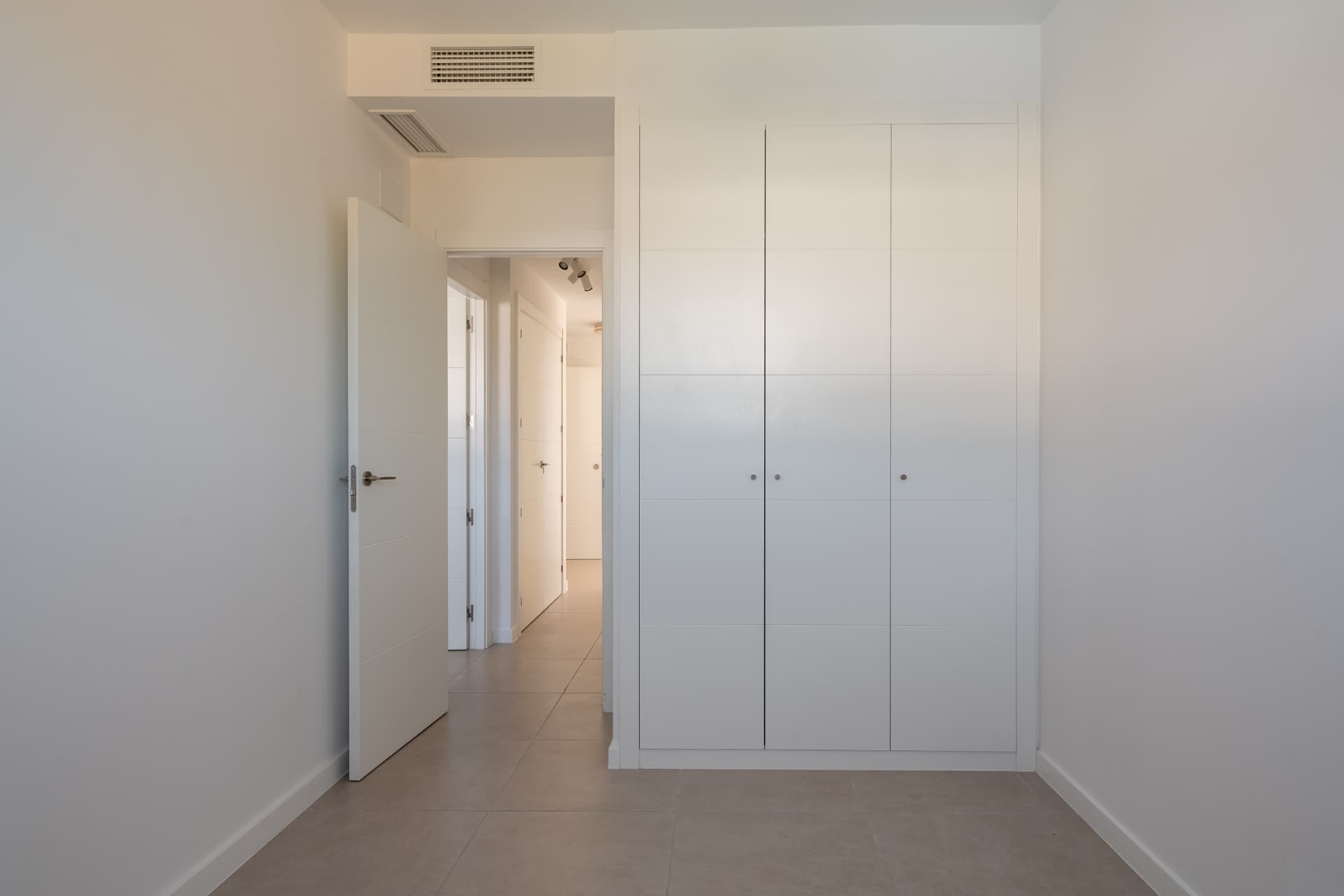 Bedroom with full-height wardrobes and hallway access