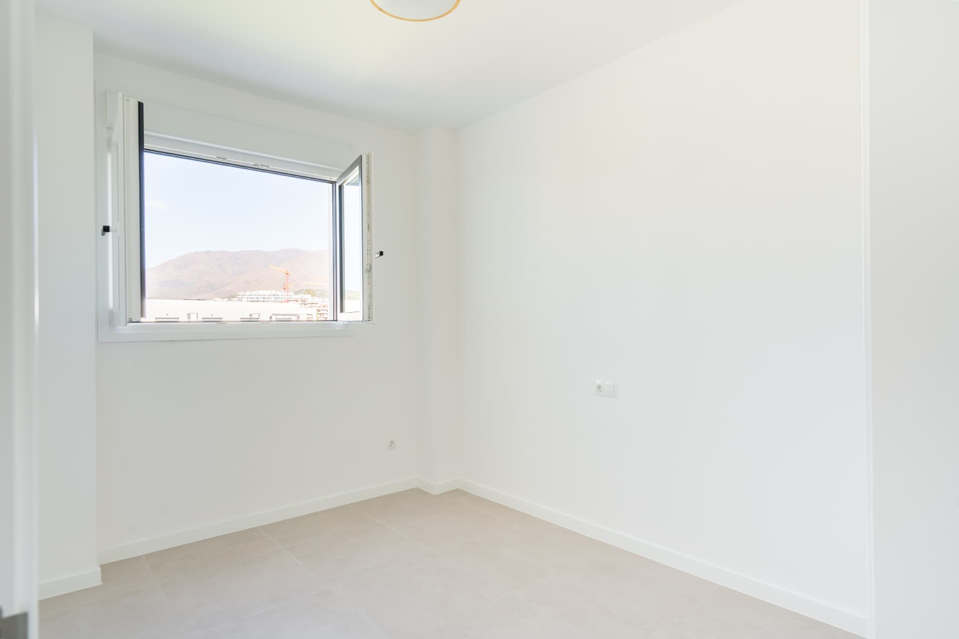 Bright bedroom with corner window and mountain views