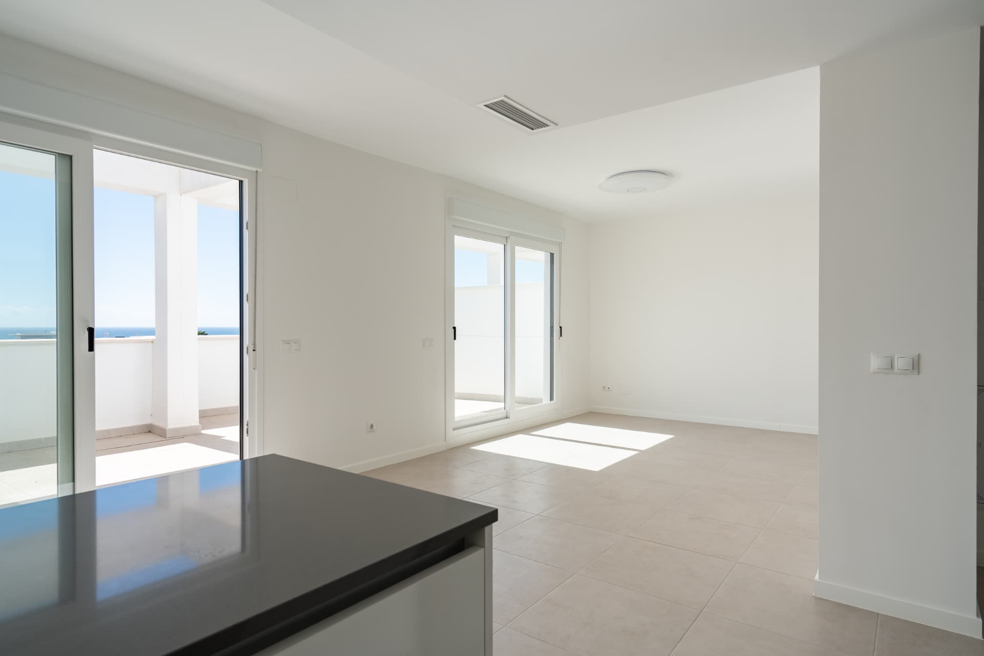 Open-plan living area with terrace access and sea views