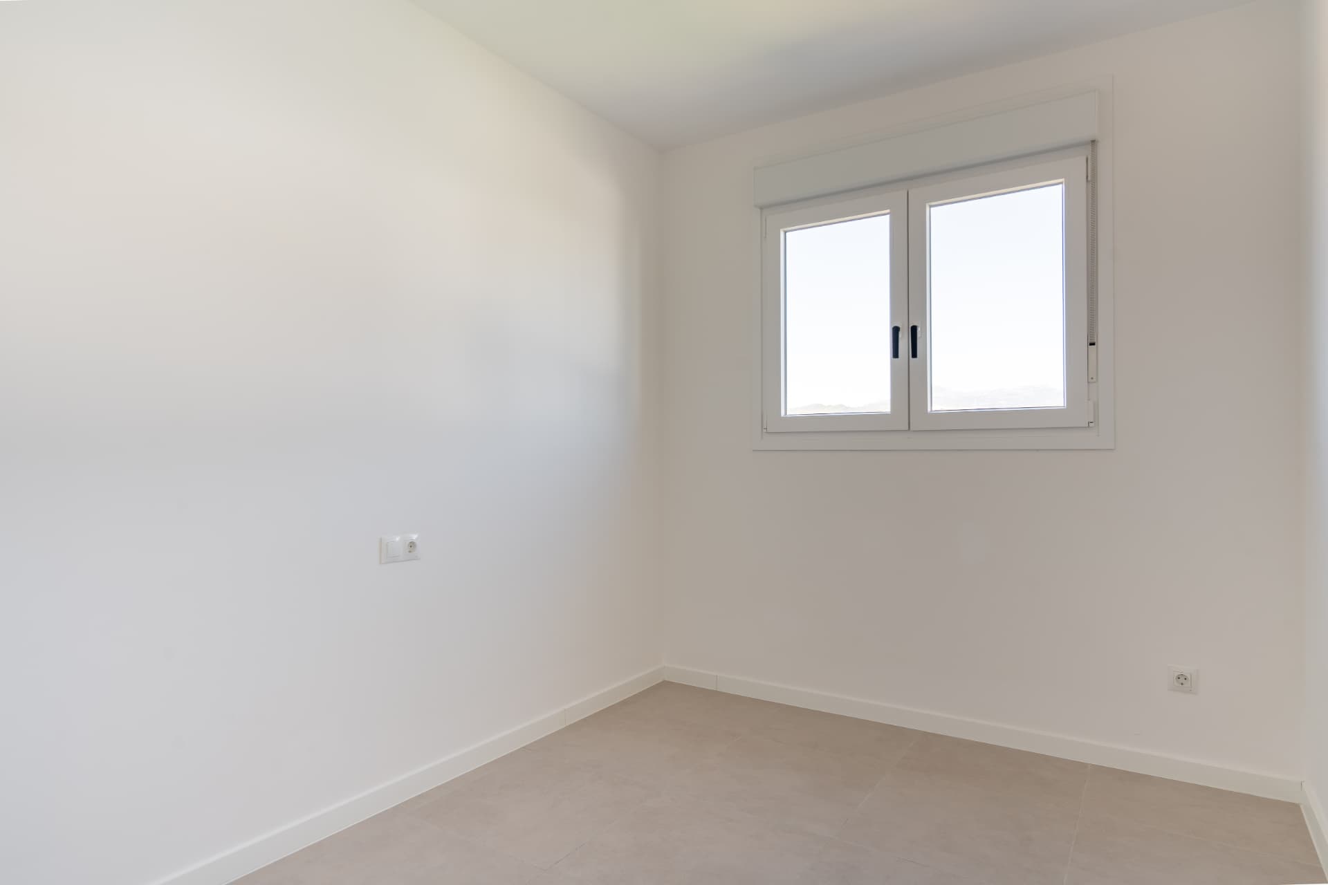 Second bedroom with window and porcelain tiled floors